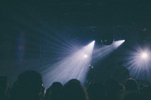 Band performing in a club with stage lights and crowd.