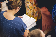 Woman reading his Bible during a church service.
