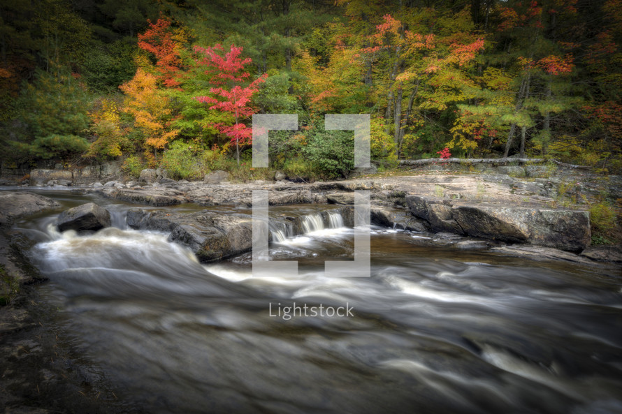 Water moving through rocky stream with fall trees