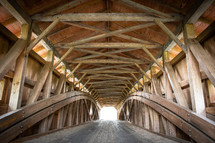 Wooden covered bridge leading to bright opening