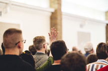 Woman raising her hand during a worship service