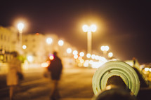 people walking on a sidewalk at night 