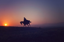 a man riding a horse at sunset 