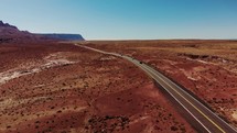 drone flying by highway through red desert