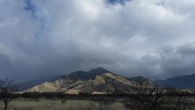 Timelapse of clearing storm clouds over a desert mountain