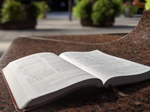 open Bible on a table outdoors 