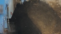 Industrial compost production site. Slow motion footage of large compost turning machine mixing compost piles