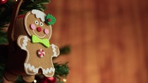 Gingerbread man decoration on a Christmas tree with falling snow and copy space