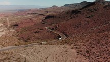 Drone is following car driving on historic route 66 going over a mountain