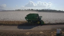 Aerial footage of cotton harvester in a large scale cotton field during harvest