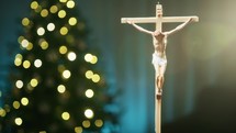 Christ Crucifix with Christmas tree in the background 