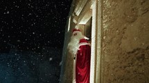 Santa walking around the street of an ancient city on Christmas snowy night 