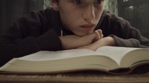 teen boy reading a Bible 