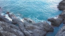 waves crashing into rocks along a shore in Italy 