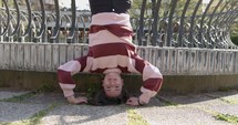 Woman doing a headstand on the ground.