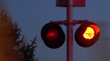 A fast train moving in front of railroad crossing lights