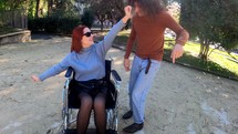 Girl in a wheelchair and guy dancing.