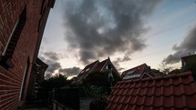 Rooftop Of The House And Tall Green Trees Under Cloudy Sky In Langeoog, Germany. wide shot