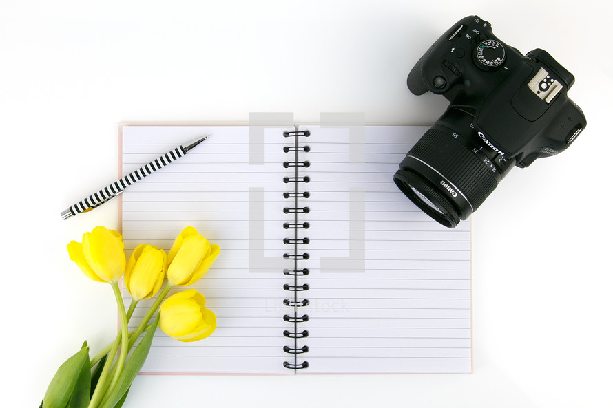 yellow tulips, notebook, blank pages, pen, and camera 