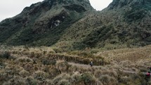 Aerial shot of Hikers Walking on The Trail With Scenic Landscape Of Cayambe Coca Ecological Reserve In Napo, Ecuador. 