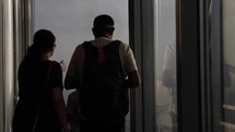 Tourists inside the top of the Burj Khalifa taking photos outside of windows at the city below.