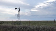 Windmill in farmland prairie grass in cinematic slow motion.
