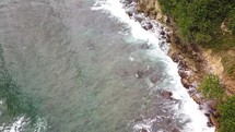 Drone's top down view of waves crashing on the rocks in the Caribbean