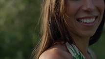 Woman outdoors in summer having fun - close up on shoulder and smiling mouth