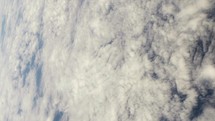 View of planet earth from space ship, space craft window with ocean and clouds in view.