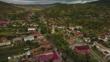 Aerial Romanian Village With Church On Cloudy Day