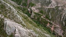 Aerial shot drone flies through mountains with zig zag Inca Trail below