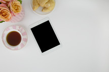 iPad, tea cup, croissant, pink and peach roses 