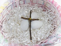 An Easter basket with a cross made out of sticks and eggs