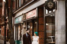 bride and groom standing on a downtown sidewalk 