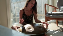 Woman playing steel handpan instrument 