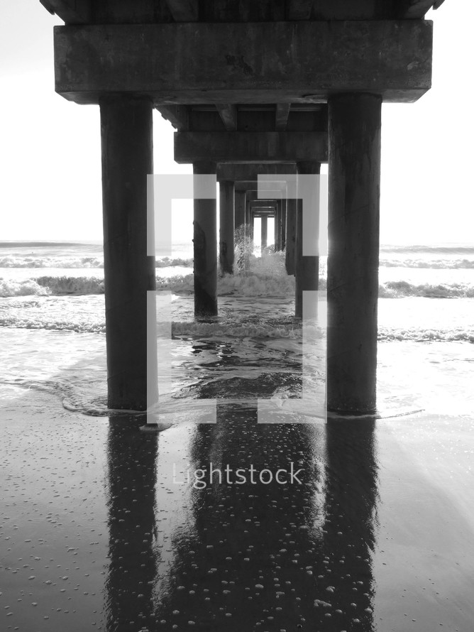 stone pillars under an ocean pier 