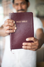 latino man holding up a Bible 