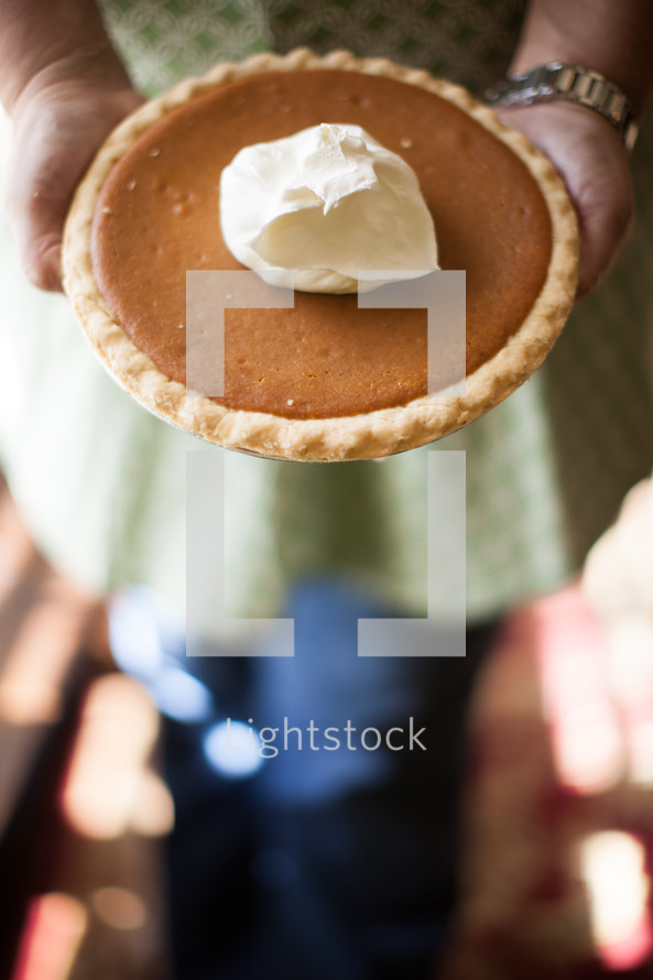 woman holding a pumpkin pie 