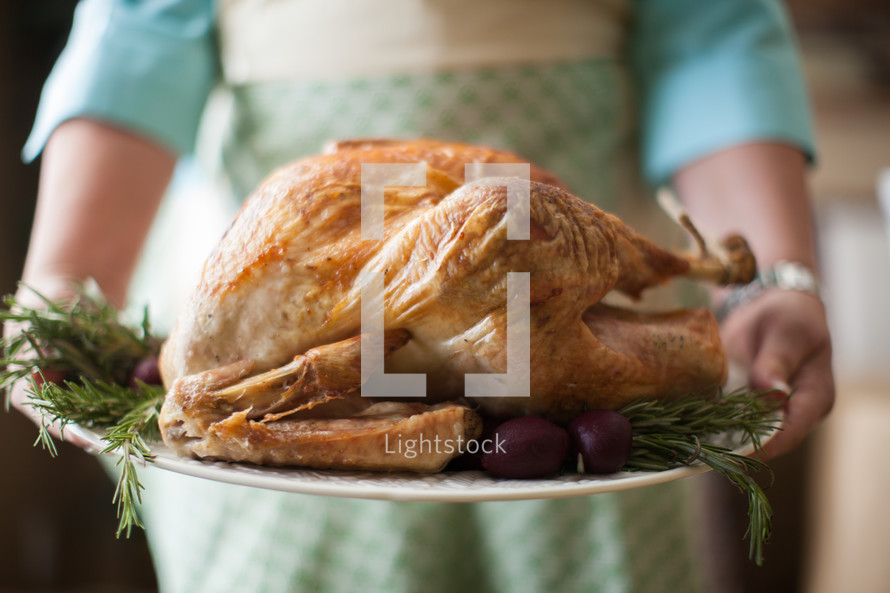 a woman holding a thanksgiving turkey 