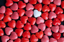 single white heart shaped candy and red and pink candy