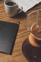 Bible, journal, and coffee on a wood table.