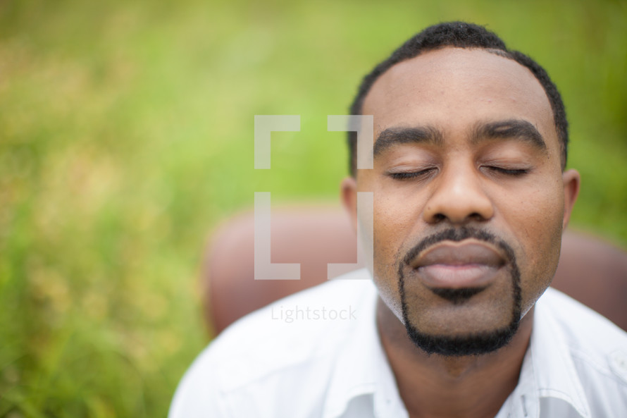 man in prayer with closed eyes 