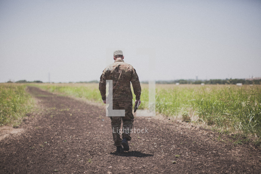 serviceman walking down a dirt road