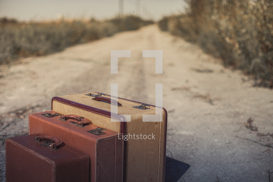 luggage on a dirt road 