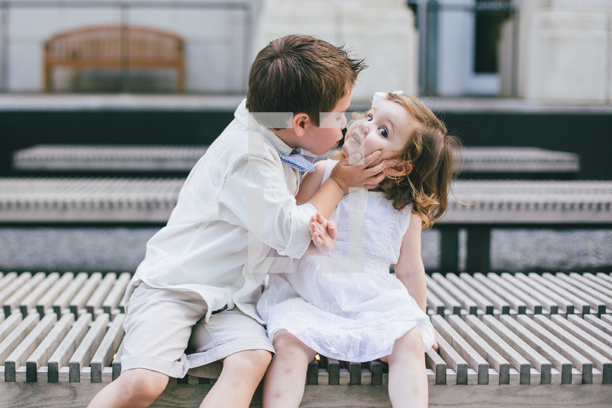 a little boy kissing a little girl 