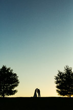 silhouette of a bride and groom kissing