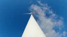 Timelapse of wind turbine under blue sky 