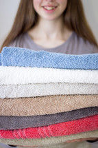 Lady holding stack of towels