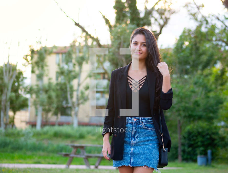 Woman in black shirt and blazer with jean skirt
