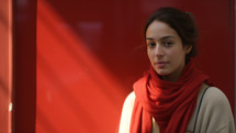 Young Woman in Red Scarf Against Red Background